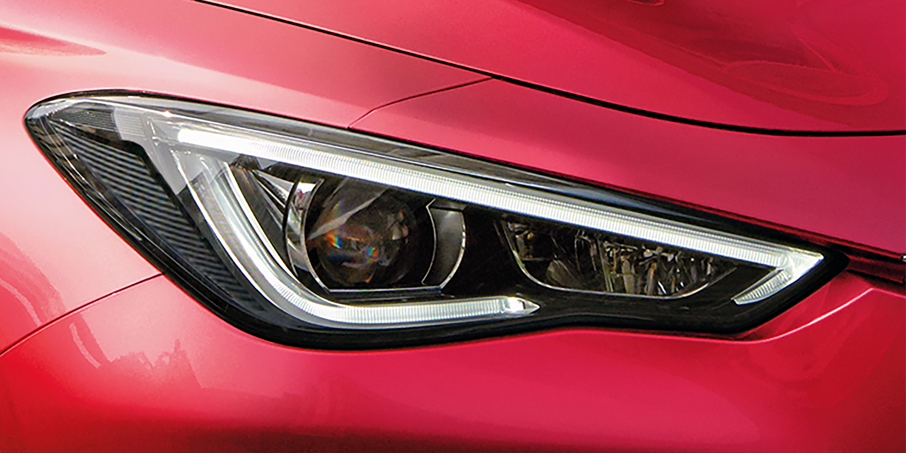 Close-up of a red 2022 INFINITI Q60 car headlight.